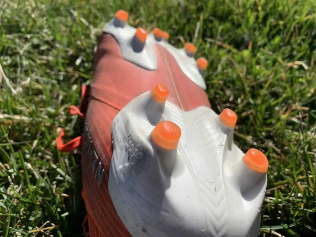 A picture of a soccer cleat with a firm ground stud pattern.